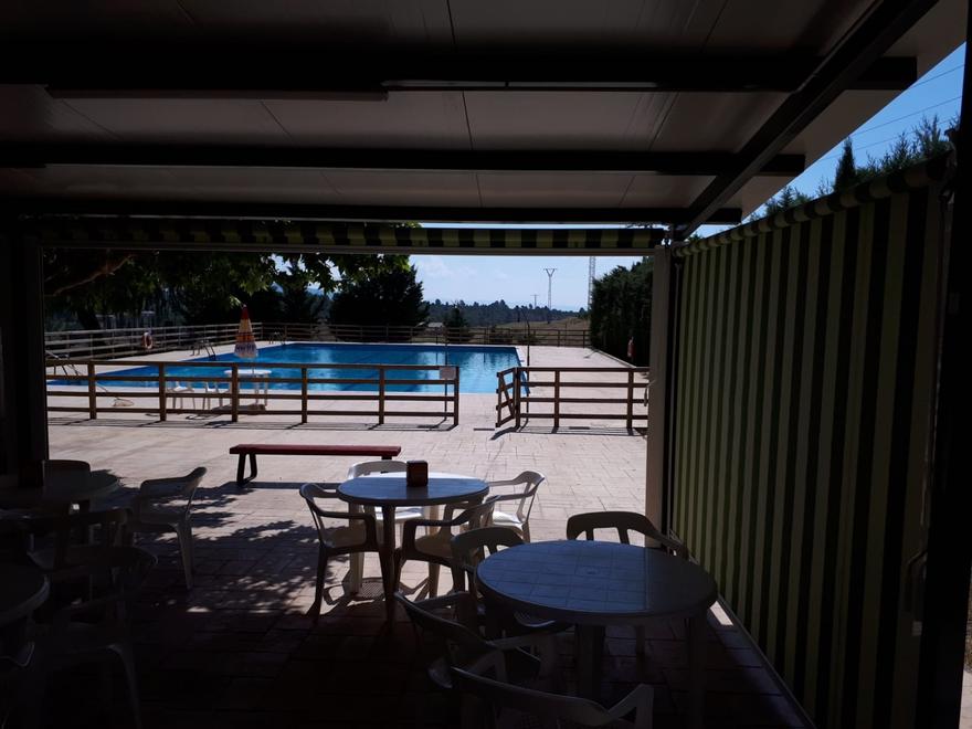 Cerramiento de toldos verticales verdes junto a una piscina
