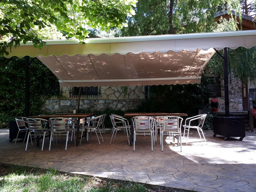 Toldo beige sobre una terraza con sillas